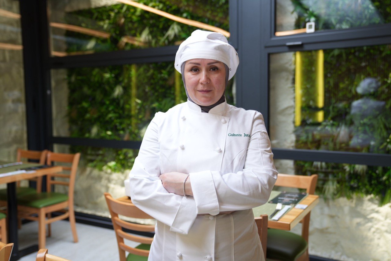 Portrait of Gulnoza Jurayeva in chef whites at her restaurant